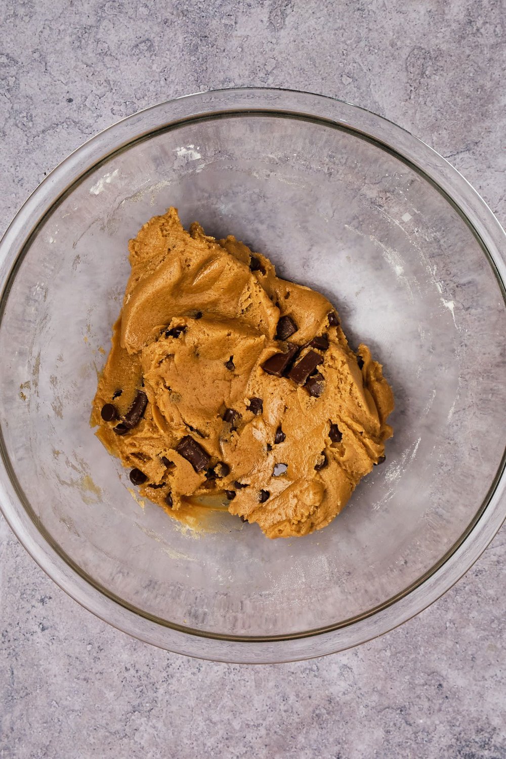 Vegan chocolate chip cookie dough in a large mixing bowl.