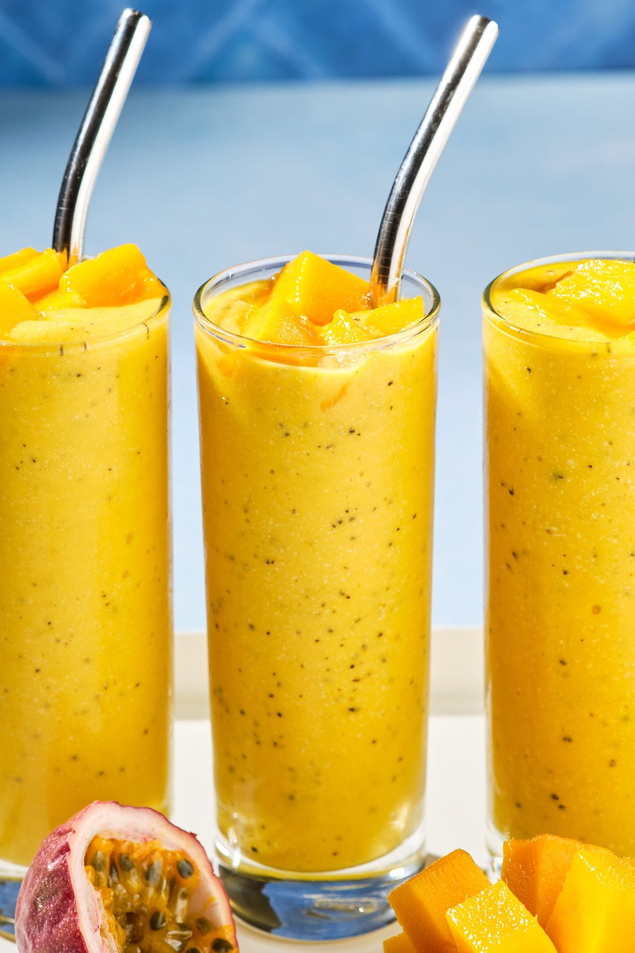 A close-up view of three mango smoothies in a line.