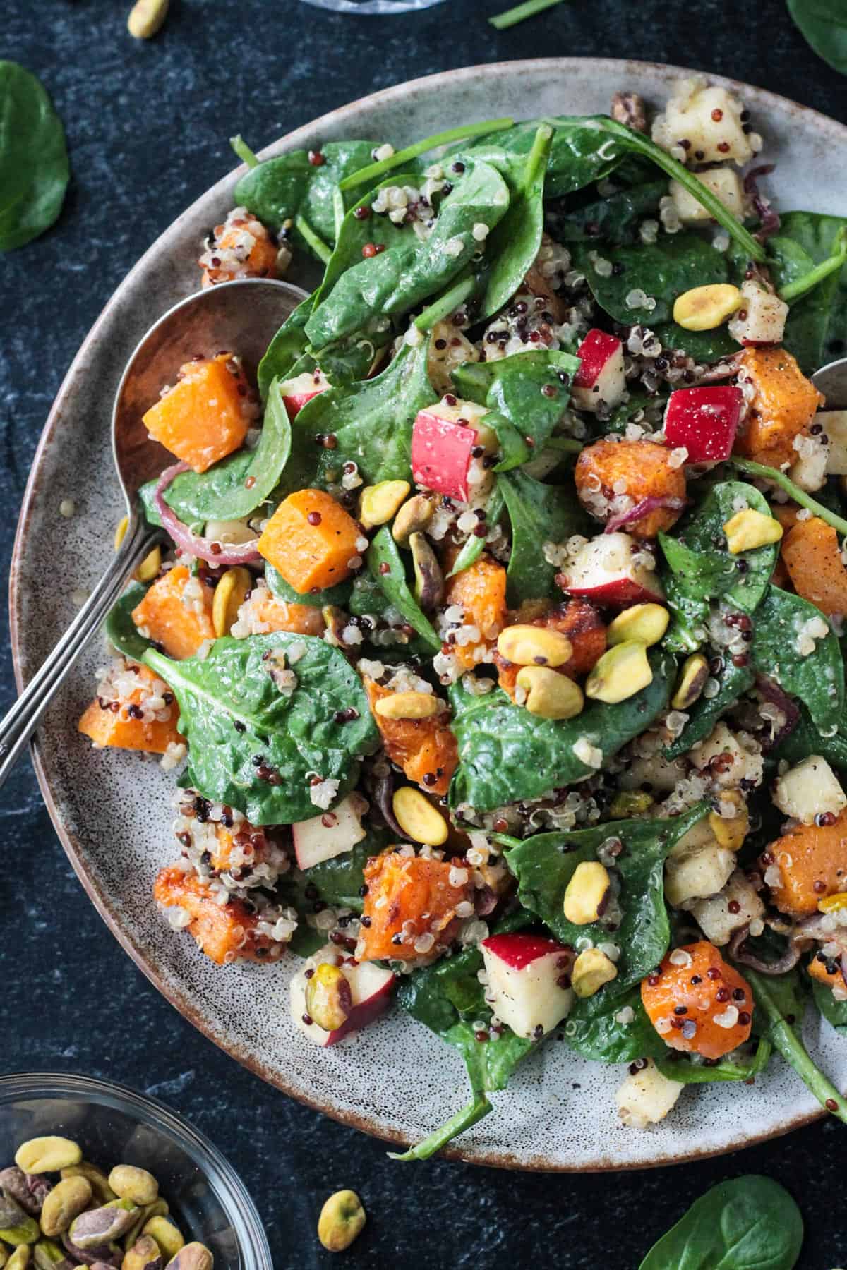 Butternut squash quinoa salad on a plate with a spoon.