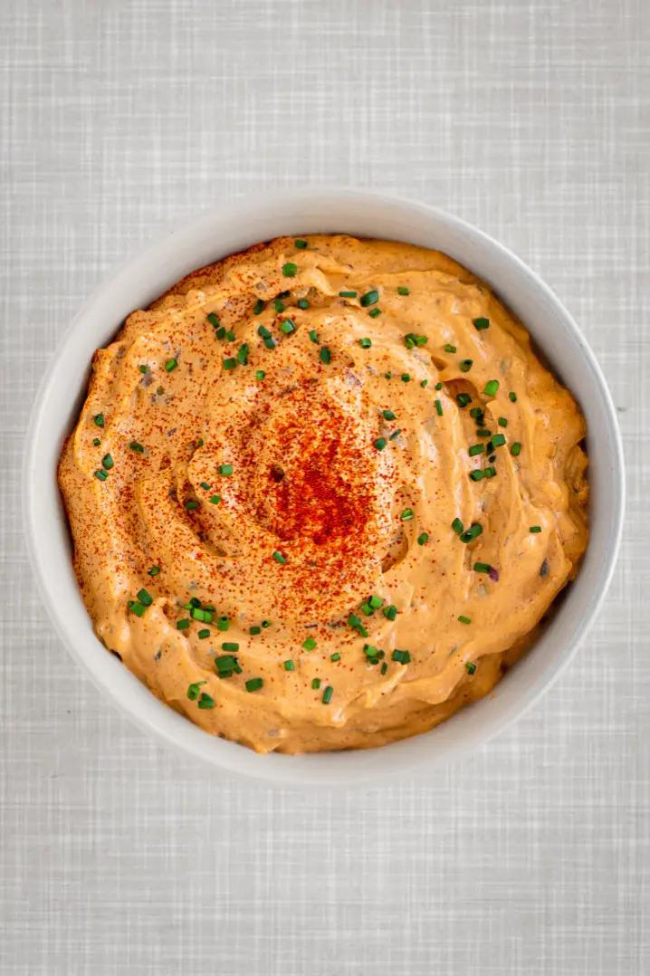 Vegan Liptauer Cheese Spread in a bowl topped with paprika and chives.