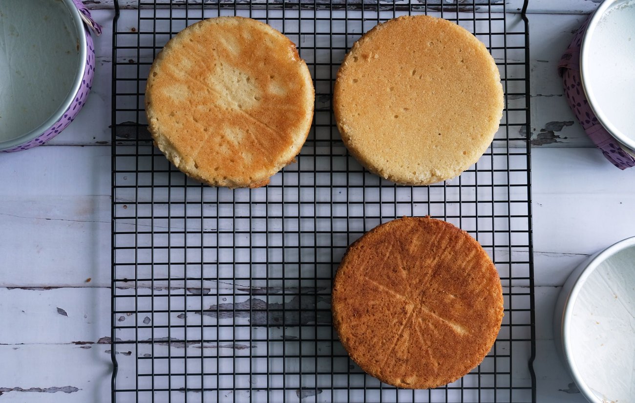 The two top cakes were prepared with cake strips; the bottom cake was prepared without a cake strip. The top left and bottom cake both had a parchment paper circle at the bottom of their pans. The top right cake's pan was greased with the cake release made of shortening, oil, and flour. (The cake pan lined with vegan butter and flour resulted in a disaster, and the cake is not shown.)
