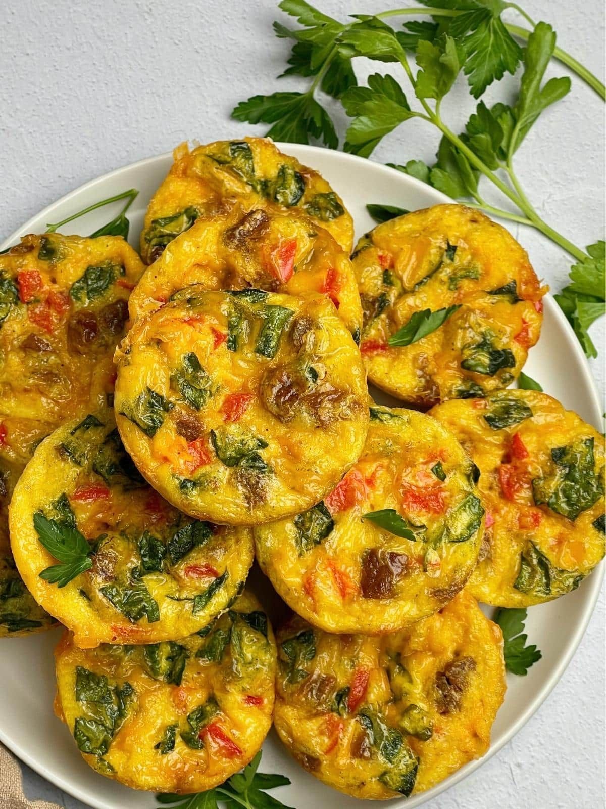 A plate of vegan egg bites next to a sprig of cilantro.