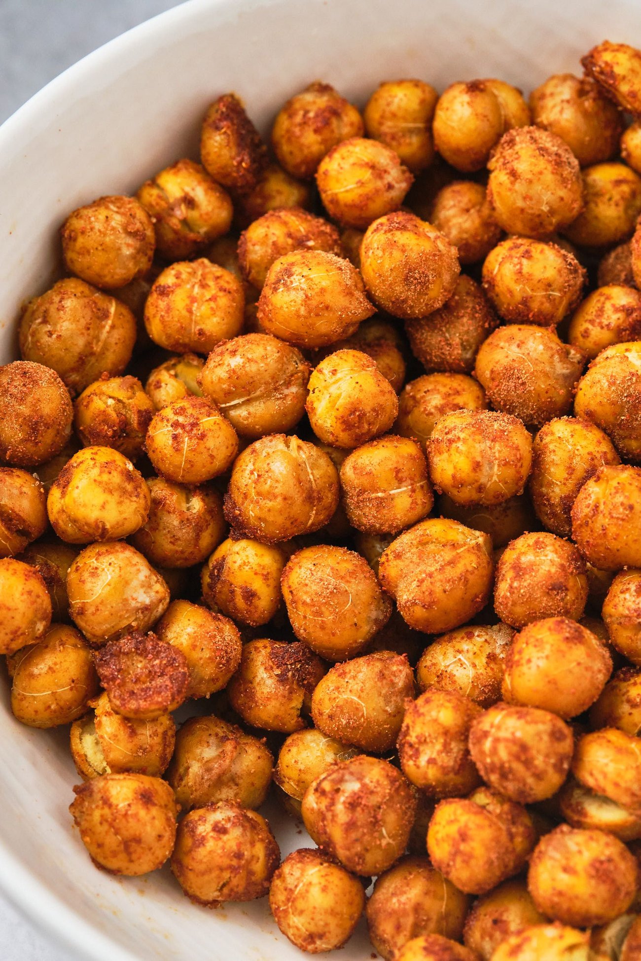 A bowl of crunchy chickpeas seasoned with paprika, allspice, and ginger powder. 