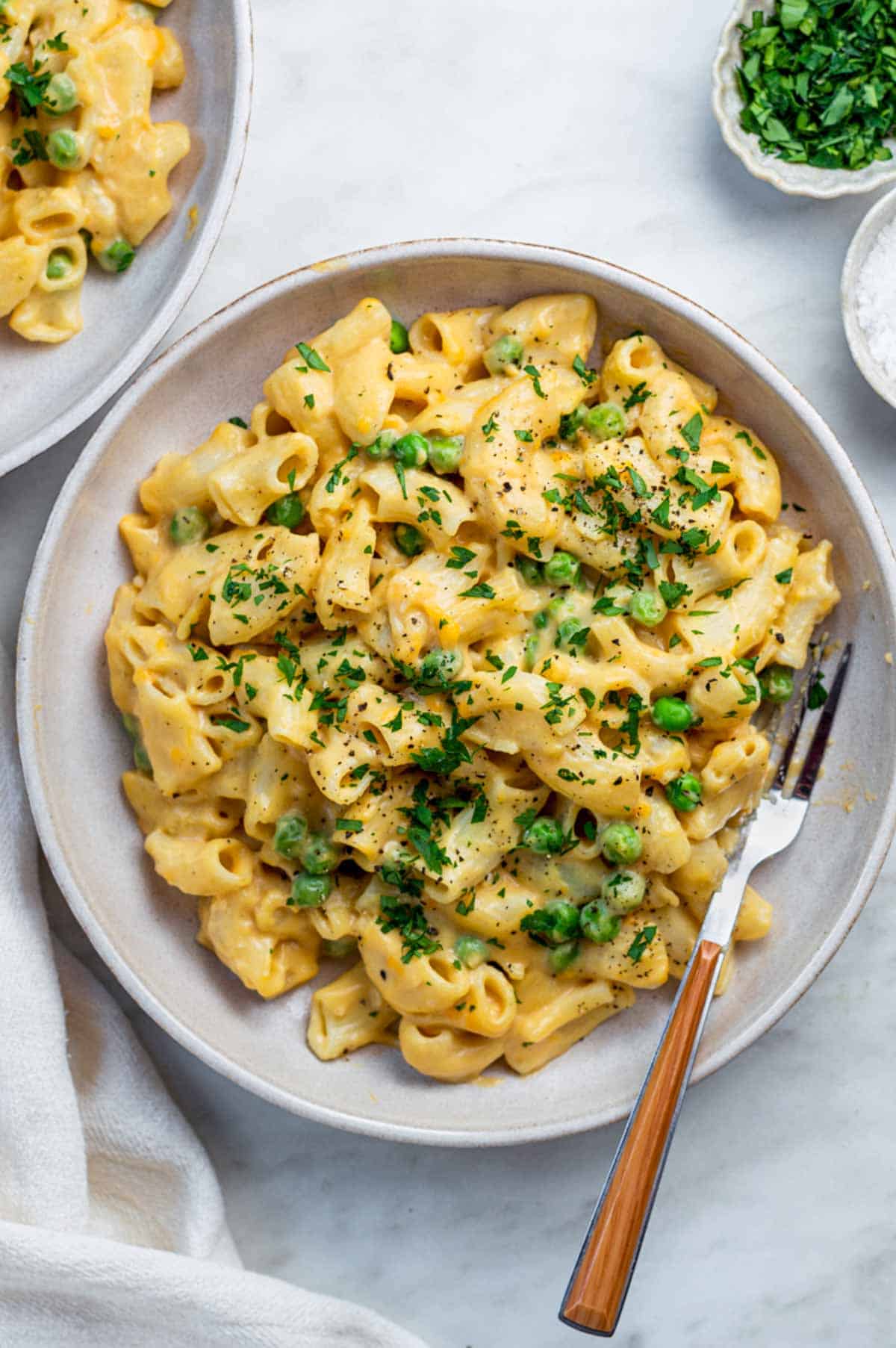 Vegan mac and cheese on a plate with peas. 