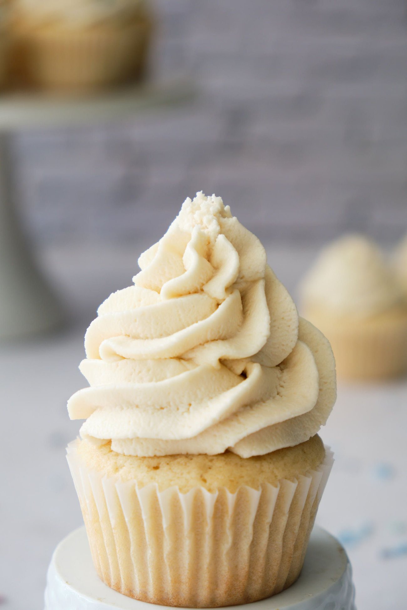 This vanilla cupcake was frosted with a large star tip, starting at the outer edges of the cupcake and spiraling inward. For thicker layers, move your piping bag slowly and push more frosting out as you move.