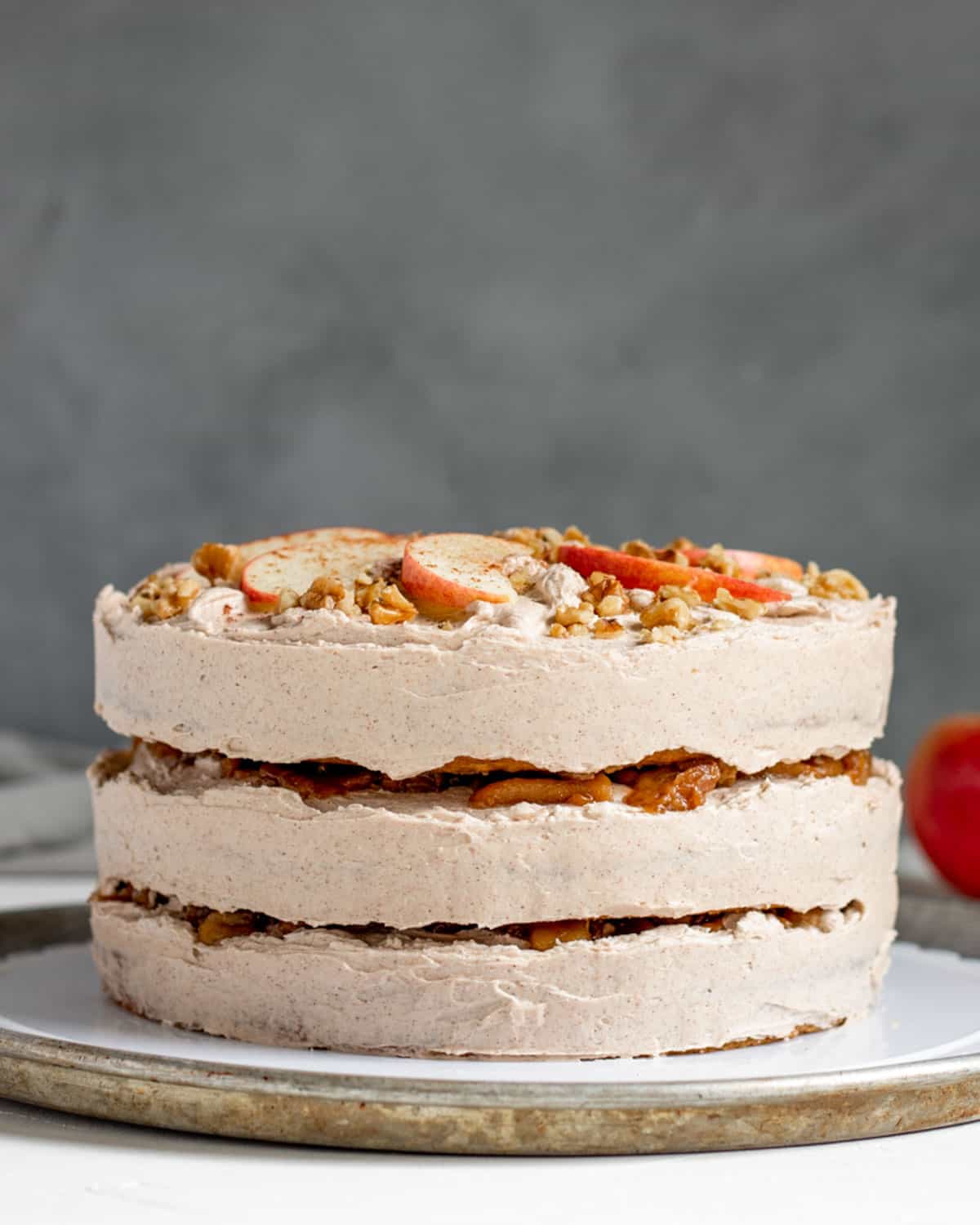 A side view of a three-layer vegan apple cake with apples between the layers. 