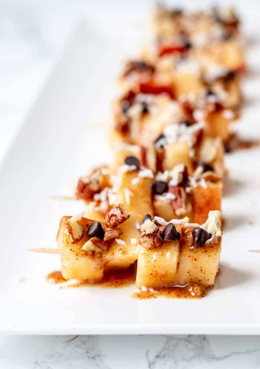 Caramel apple skewers on a platter. 