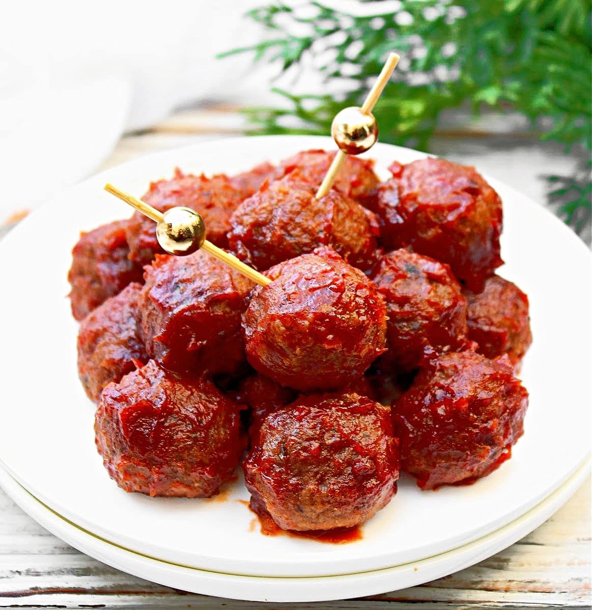 A plate of vegan cocktail meatballs with cocktail picks in two of them. 