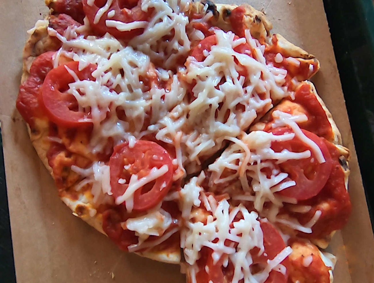 The vegan margherita flatbread comes with beautiful slices of tomatoes.