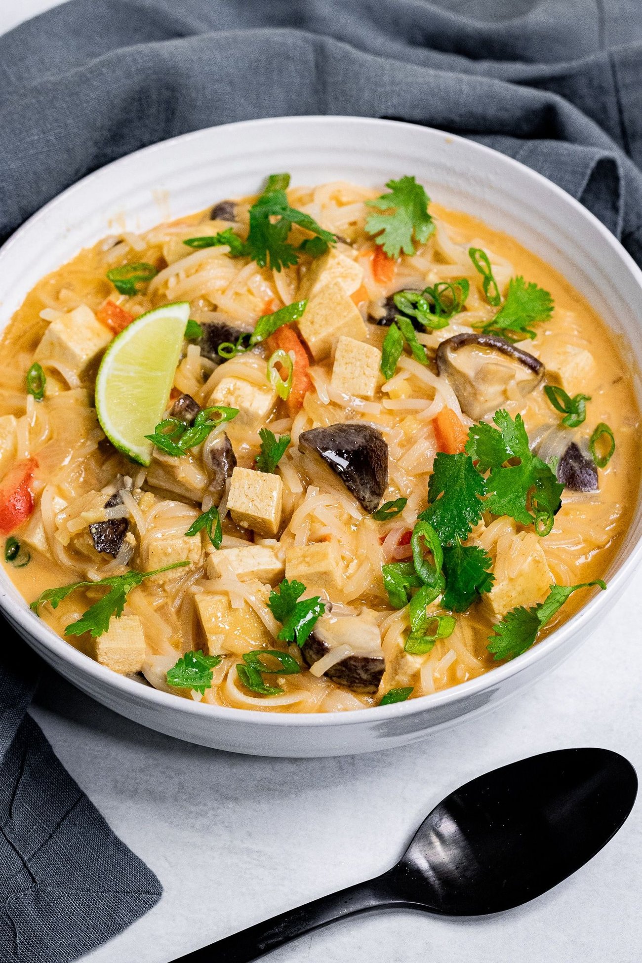 A bowl of vegan tom kha with a spoon.
