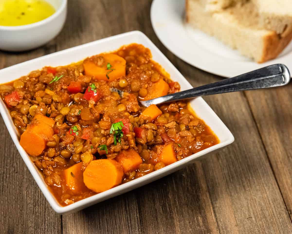 Spanish lentil stew with soyrizo in a bowl with a spoon. 