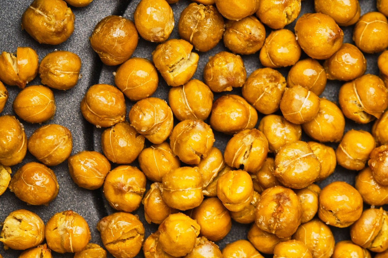 A close-up view of air fryer chickpeas in an air fryer basket. 