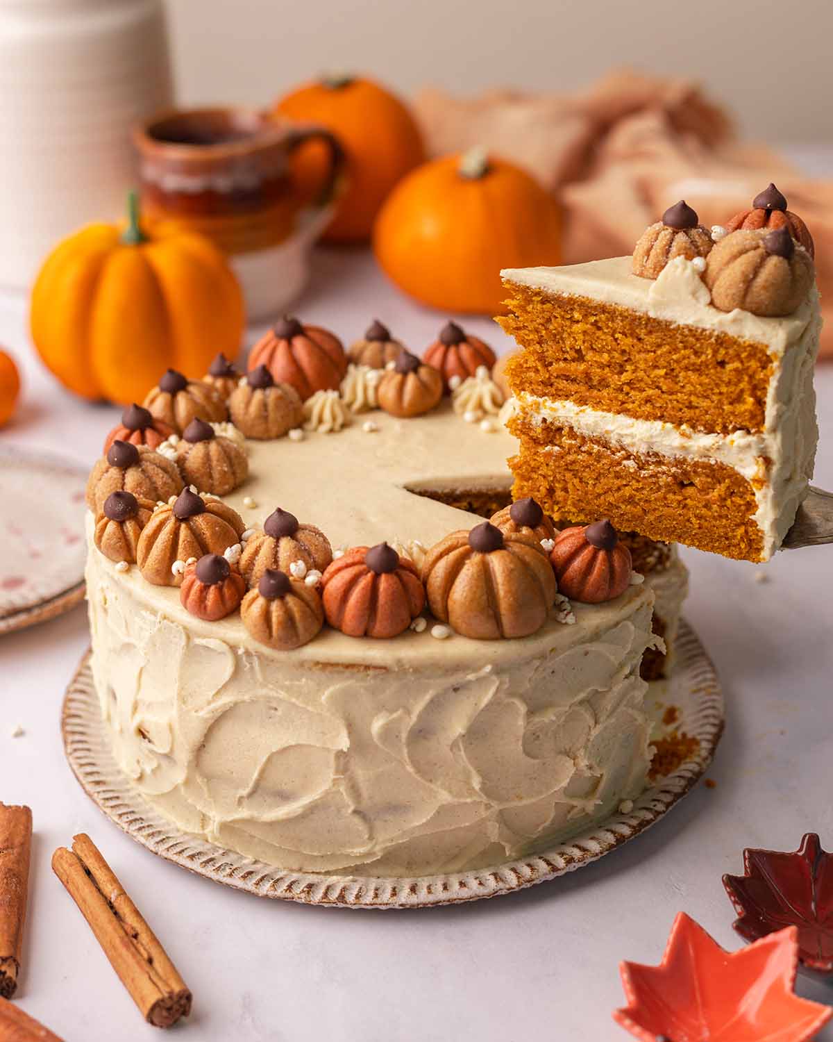 A slice being removed from a vegan pumpkin cake with a cake server.