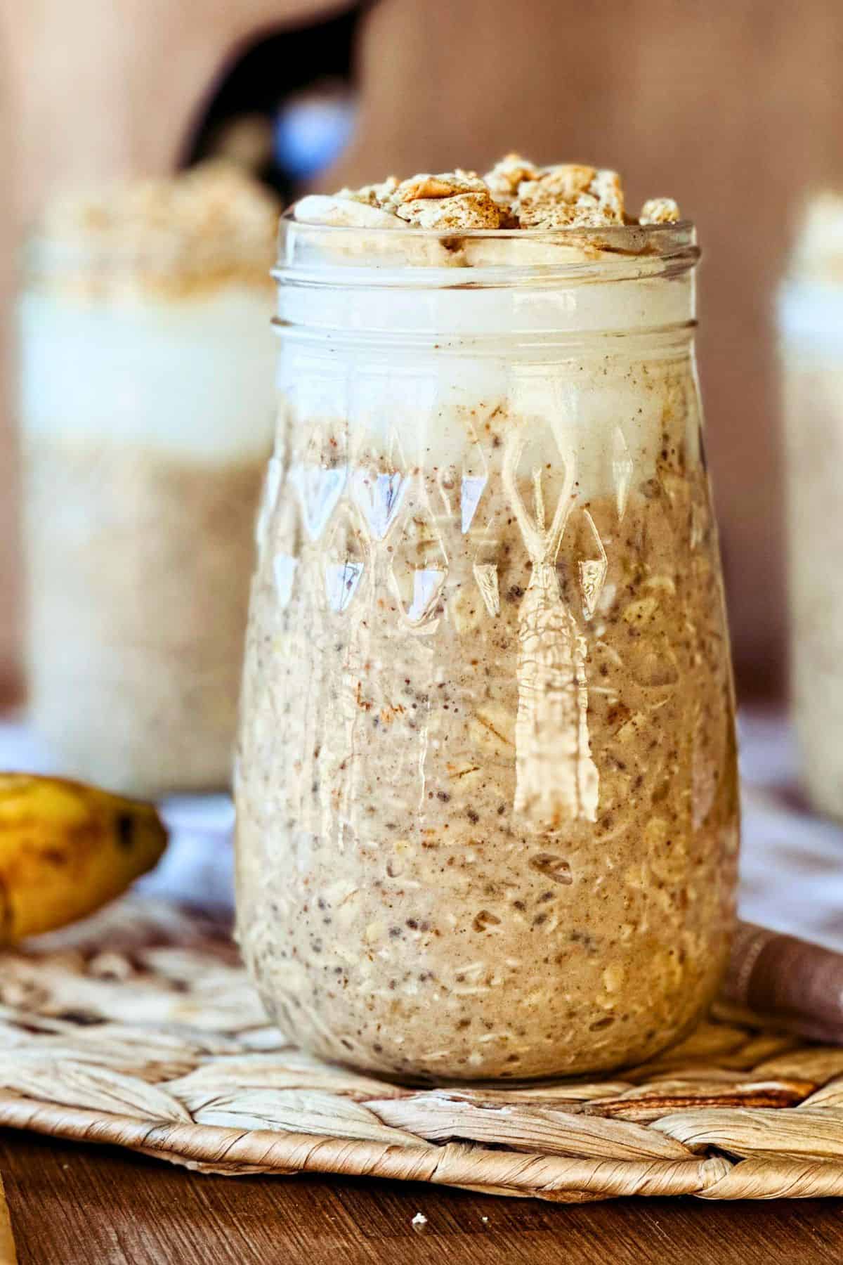 A mason jar of vegan banana cream pie overnight oats on a table.