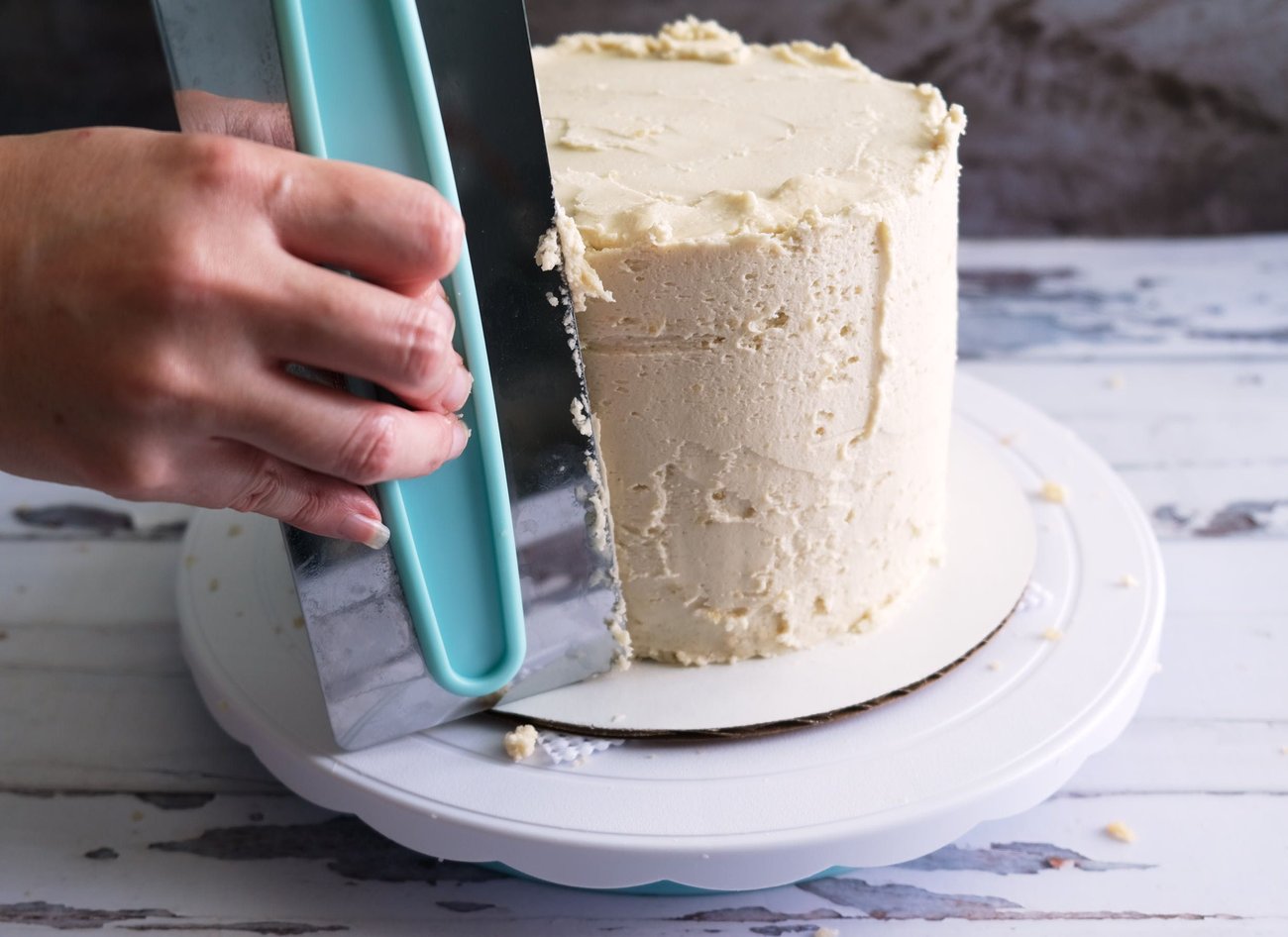 Use your icing smoother to get the first layer of frosting smooth and thin.
