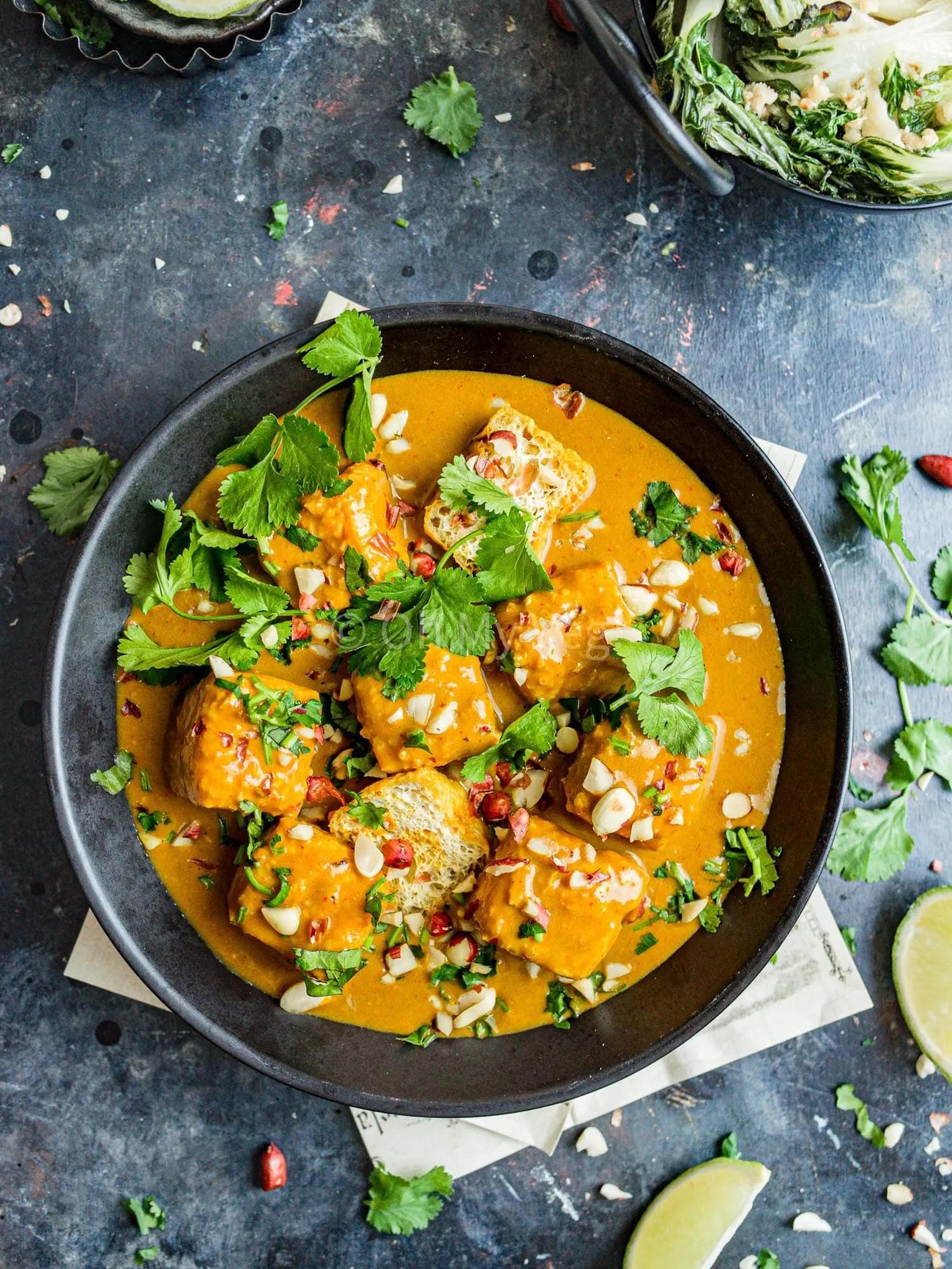 Vegan Tofu Satay Curry in a bowl topped with greens.
