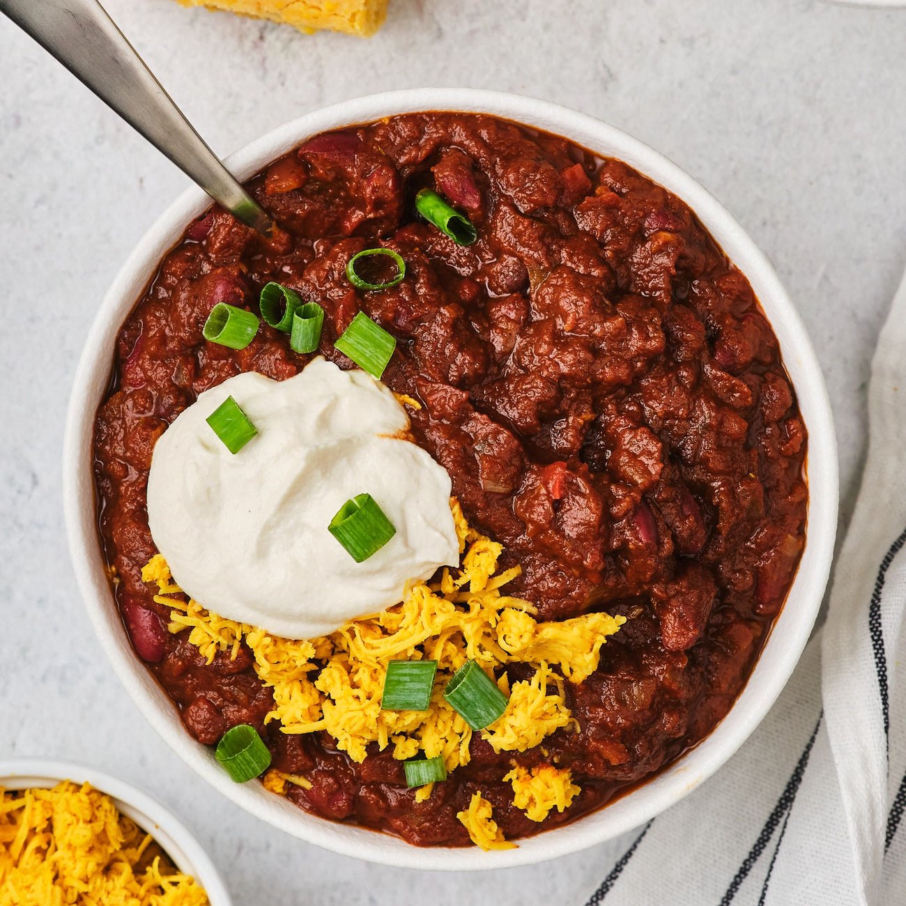 A top-down view of vegetarian chili in a bowl with a spoon. 