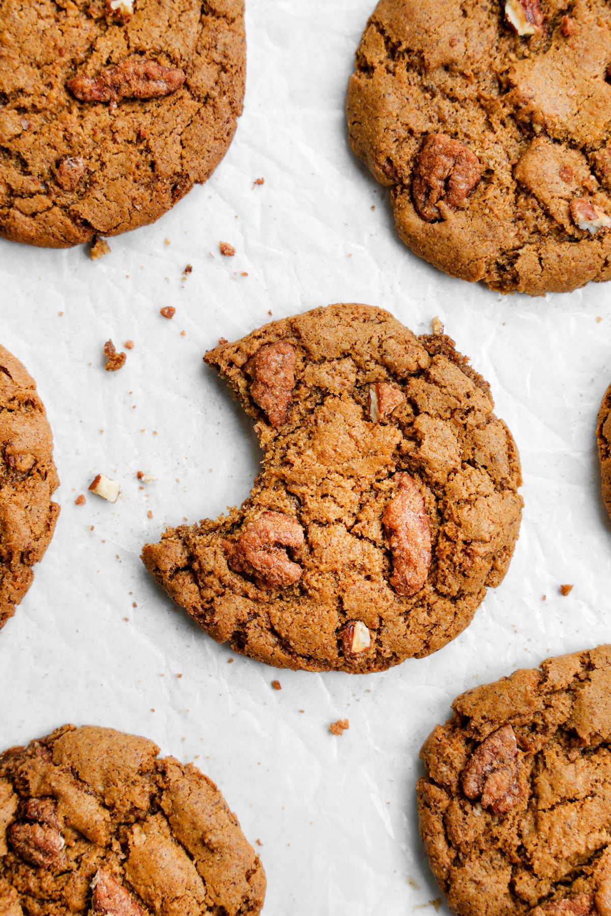 Vegan candied pecan cookies on a sheet of parchment paper.