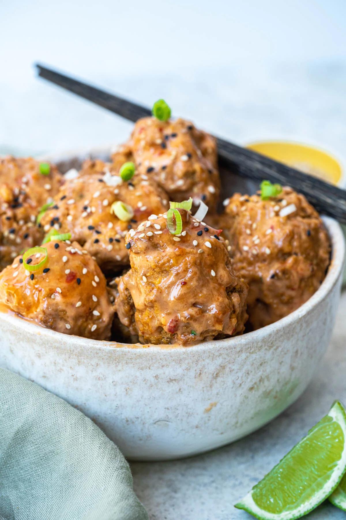 A bowl of bang bang cauliflower with a pair of chopsticks. 