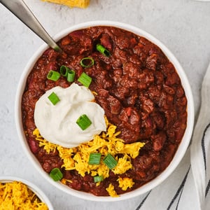 A top-down view of vegetarian chili in a bowl with a spoon. 