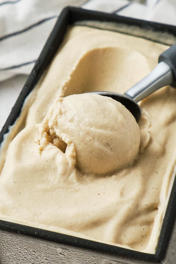 No-churn vegan vanilla ice cream being scooped out of a loaf pan.
