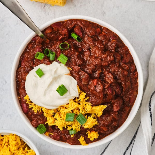 A top-down view of vegetarian chili in a bowl with a spoon. 
