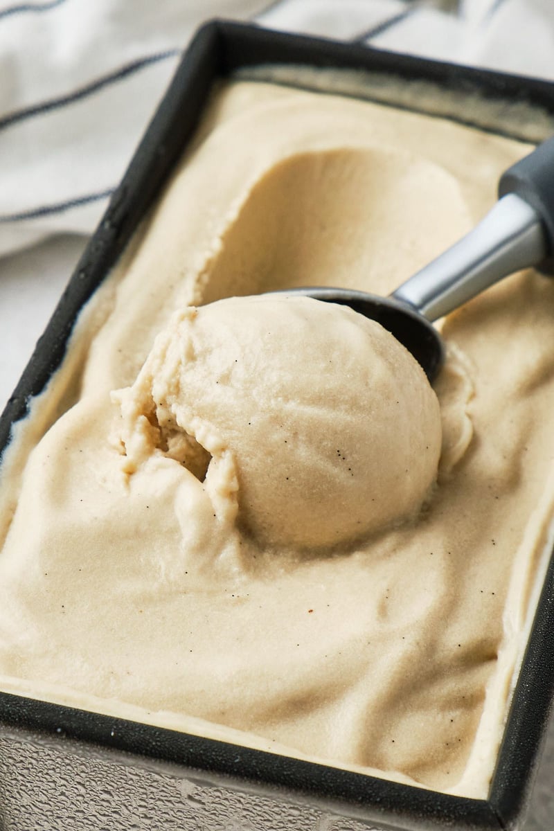 No-churn vegan vanilla ice cream being scooped out of a loaf pan.