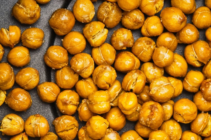 A close-up view of air fryer chickpeas in an air fryer basket. 
