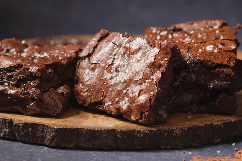 A close-up view of a brownie turned on its side, with stacks of brownies to the sides.