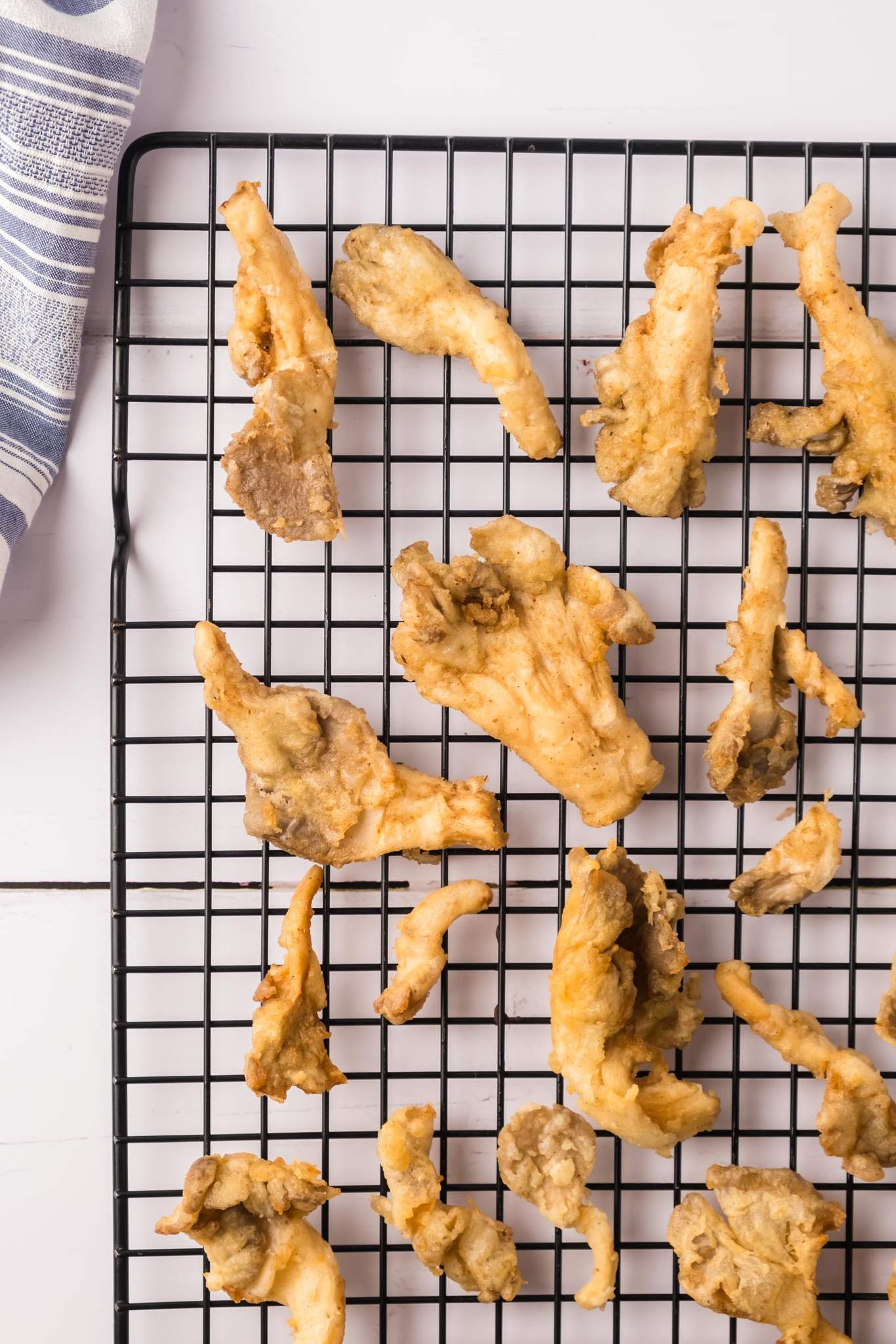 Fried oyster mushrooms on a wire rack.