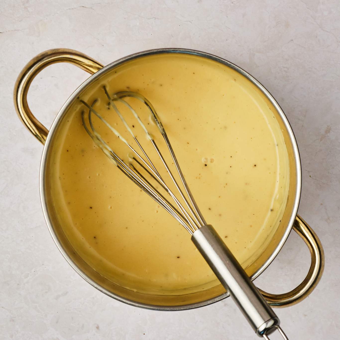 Finished vegan fondue in a pot with a whisk. 
